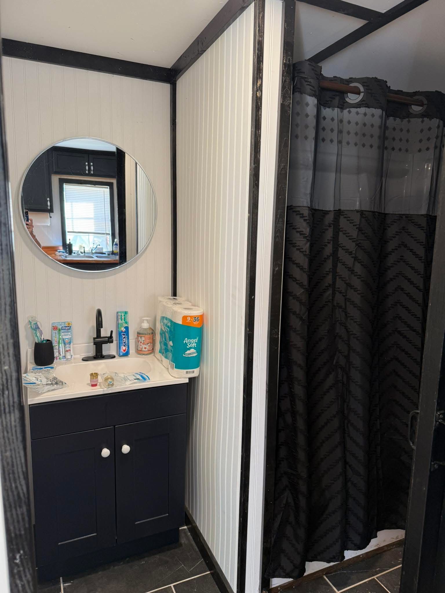Tiny house bathroom with vanity, mirror, and shower